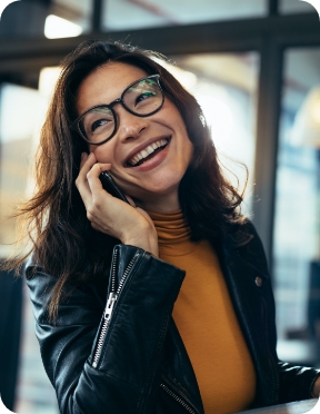 Insurance agent smiles and speaks on a cell phone.